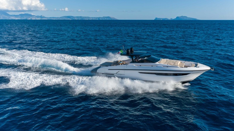 A recreational boat with electric motor at a coastal town with mountains in the background