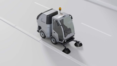 A sweeping machine with surround sensing, electric drive, and driver assistance cleaning a road 