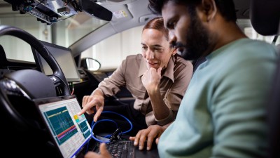 Zwei Personen aus dem Team Safety Management von Bosch Engineering mit Laptop in einem Fahrzeug. 